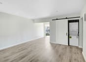 Thumbnail 7 of 47 - an empty living room with white walls and a washer and dryer in it