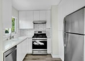 Thumbnail 1 of 47 - a kitchen with white cabinets and a stainless steel refrigerator