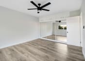 Thumbnail 16 of 47 - an empty living room with white walls and a ceiling fan