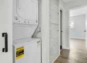 Thumbnail 11 of 47 - a white washer and dryer in a room with a hallway and a door