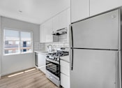 Thumbnail 27 of 47 - A modern kitchen with a refrigerator, stove, and oven.