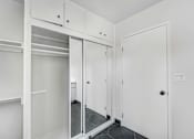 Thumbnail 29 of 47 - A white closet with a mirror and shelves.