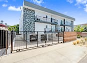 Thumbnail 40 of 47 - A modern two-story house with a white and grey exterior and a black metal fence.