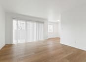 Thumbnail 1 of 23 - A room with wooden flooring and a window with blinds.
