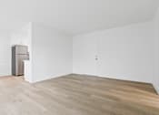Thumbnail 2 of 23 - A room with a wooden floor and white walls.