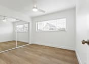 Thumbnail 7 of 23 - A room with a wooden floor and a ceiling fan.