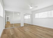 Thumbnail 9 of 23 - A room with wooden floors and a ceiling fan.