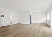 Thumbnail 11 of 23 - A room with wooden flooring and white walls.