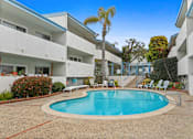 Thumbnail 22 of 23 - A swimming pool in a courtyard surrounded by white buildings.