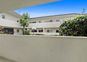 Thumbnail 12 of 23 - A white building with a tree in front of it.