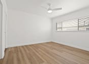Thumbnail 18 of 23 - A room with a ceiling fan and wooden flooring.