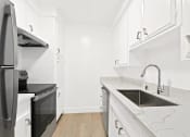 Thumbnail 14 of 39 - a kitchen with white cabinets and a sink and a refrigerator