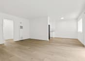 Thumbnail 13 of 39 - an empty living room with white walls and wood flooring