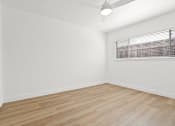 Thumbnail 6 of 39 - an empty room with white walls and wood floors and a window