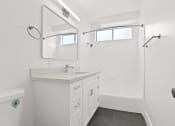 Thumbnail 8 of 39 - a bathroom with a sink and a shower and a mirror