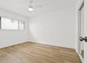 Thumbnail 9 of 39 - an empty room with wood flooring and a ceiling fan