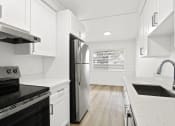 Thumbnail 4 of 39 - an all white kitchen with white cabinets and a stainless steel refrigerator
