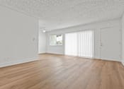 Thumbnail 29 of 39 - A room with wooden flooring and white walls.