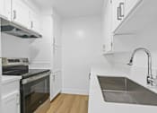 Thumbnail 32 of 39 - A modern kitchen with white cabinets and stainless steel appliances.