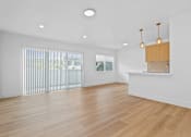 Thumbnail 21 of 39 - A room with wooden floors and a window with blinds.