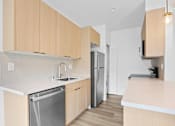 Thumbnail 24 of 39 - A kitchen with wooden cabinets and a stainless steel dishwasher.