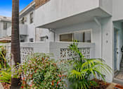 Thumbnail 2 of 11 - A white house with a blue door and a number 2 on it.