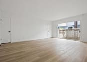 Thumbnail 1 of 11 - A room with wooden flooring and white walls.