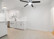 Thumbnail 4 of 11 - A white kitchen with a fan on the ceiling.
