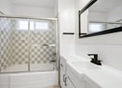 Thumbnail 9 of 11 - A white bathroom with a checkered shower door.
