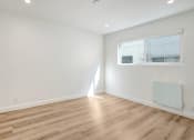 Thumbnail 17 of 34 - a living room with white walls and a window