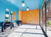 Thumbnail 3 of 4 - A blue room with a black chair and a brown wall.