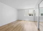 Thumbnail 14 of 24 - A room with wooden flooring and white walls.