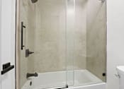 Thumbnail 17 of 24 - A white bathroom with a glass shower door.