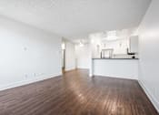 Thumbnail 2 of 11 - A room with wooden floors and white walls.