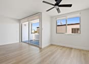 Thumbnail 21 of 56 - A room with a ceiling fan and sliding glass doors.