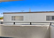 Thumbnail 22 of 56 - A white building with a balcony and a small antenna on top.