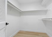 Thumbnail 27 of 56 - A white room with a black door handle and wooden flooring.
