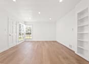 Thumbnail 1 of 11 - A room with wooden floors and white walls.