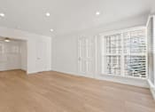Thumbnail 2 of 11 - A room with wooden floors and white walls.