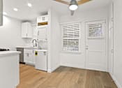 Thumbnail 4 of 11 - A kitchen with white cabinets and a wooden floor.