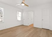 Thumbnail 6 of 11 - A room with a ceiling fan and three doors.