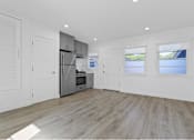 Thumbnail 1 of 42 - A spacious kitchen with wooden flooring and white walls.