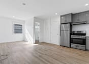 Thumbnail 3 of 42 - A kitchen with a refrigerator, oven, and microwave.