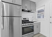Thumbnail 5 of 42 - A modern kitchen with a stainless steel refrigerator and oven.