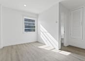 Thumbnail 6 of 42 - A room with a window and wooden flooring.