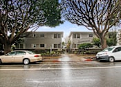 Thumbnail 12 of 42 - A car is parked on the street in front of a house.
