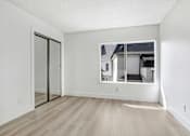 Thumbnail 15 of 24 - A room with a sliding glass door and wooden flooring.