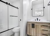 Thumbnail 17 of 24 - A bathroom with a white toilet and a wooden cabinet.