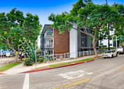 Thumbnail 24 of 24 - A street view with a car driving on the road and a building on the side.