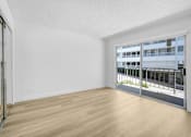 Thumbnail 5 of 24 - A room with a sliding glass door leading to a balcony.